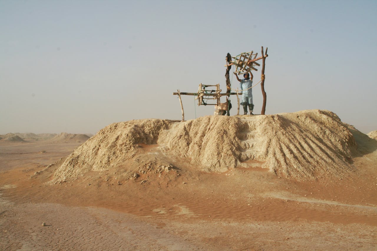 A man working on a traditional mining setup in the arid landscape of Morocco